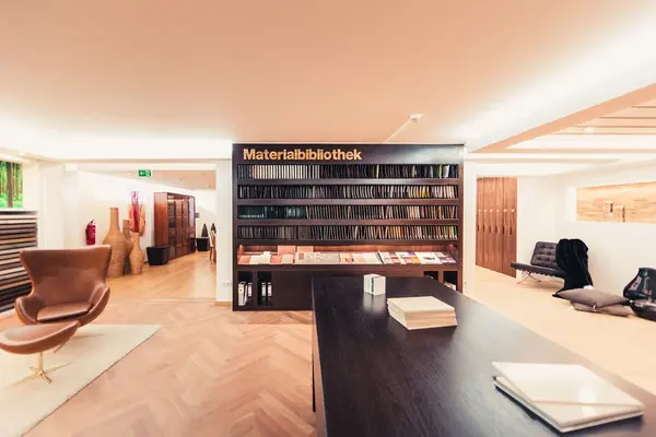 Moderne Materialbibliothek mit Mustern und stilvollen Möbeln in heller Innenarchitektur.