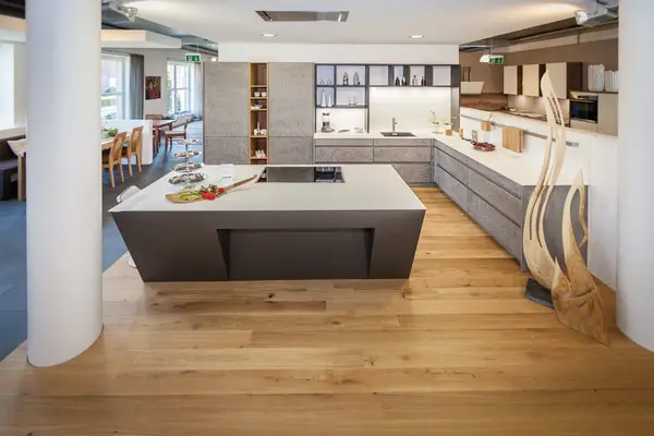 Moderne offene Küche mit Kochinsel, Holzfußboden und stilvollen Designermöbeln.